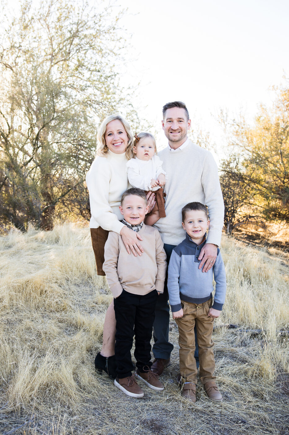 Family with two little boys and one baby girl in a field. 