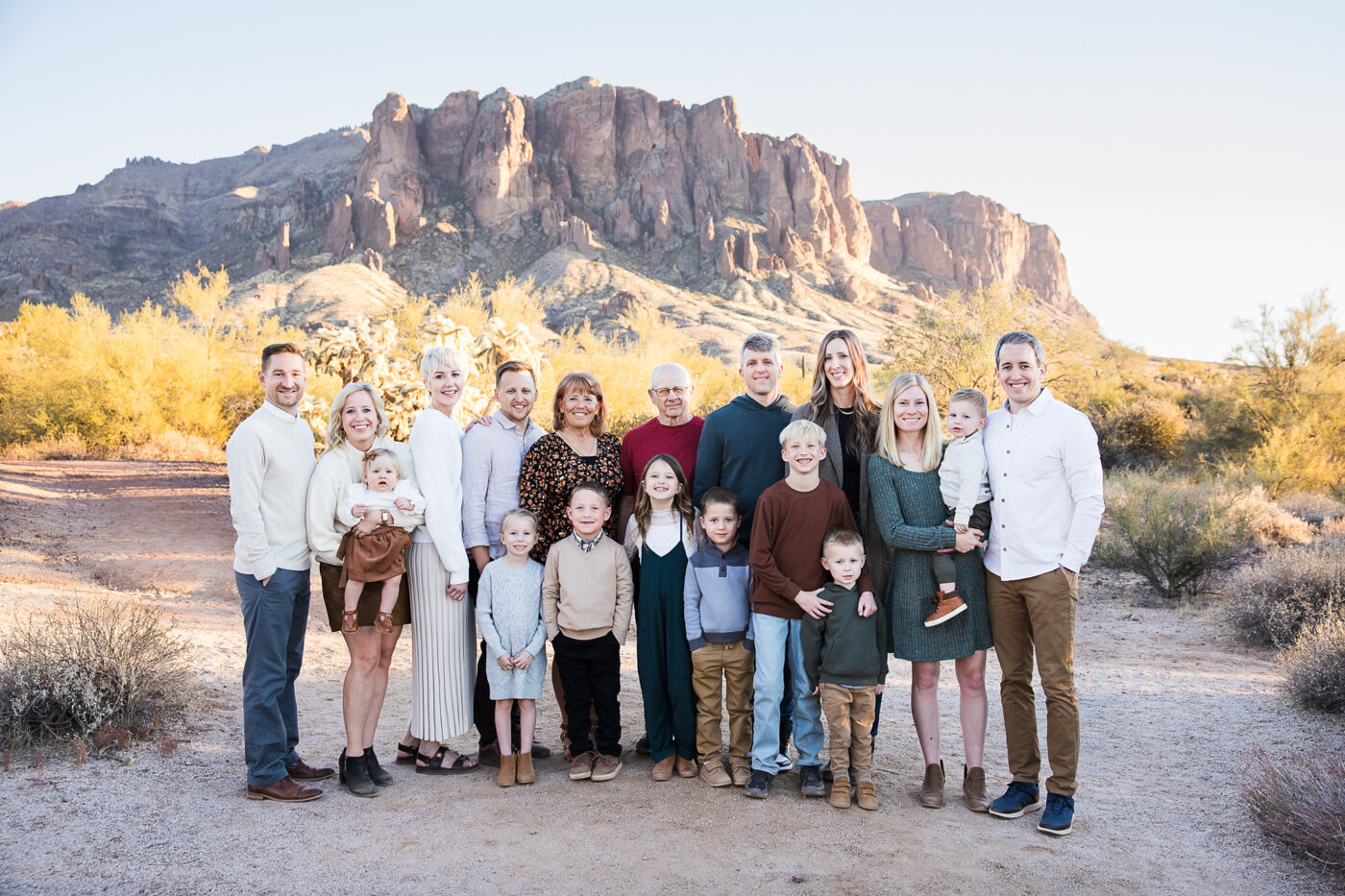 Extended family in front of Superstition Mountain smiling at camera.