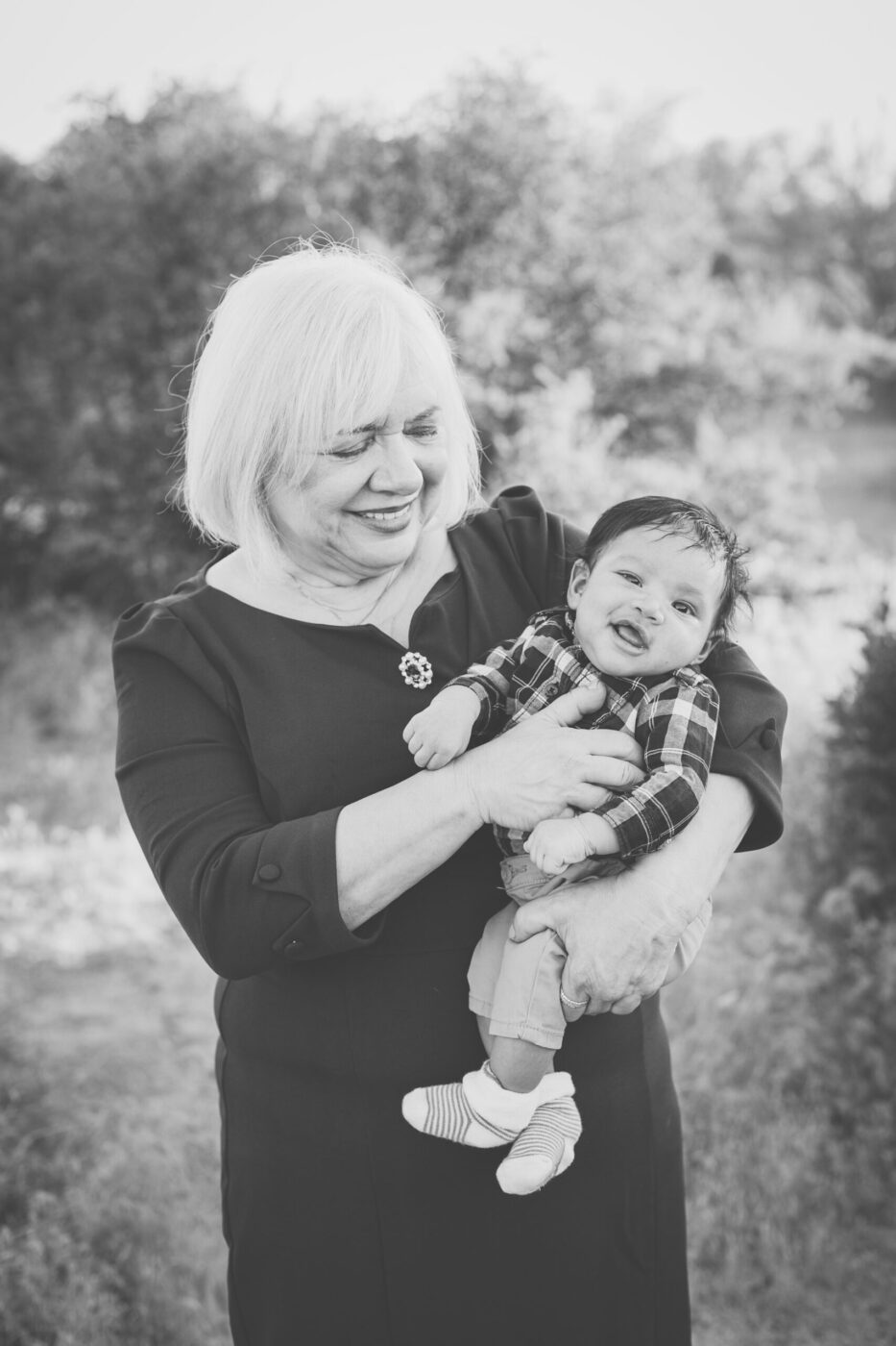 Grandma looking baby granddaughter she's holding.