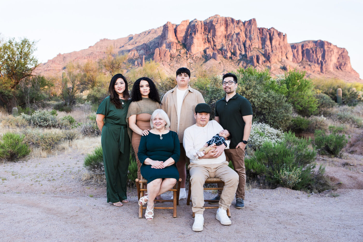 Family with older kids and grandparents in front of Superstition Mountain at sunset.