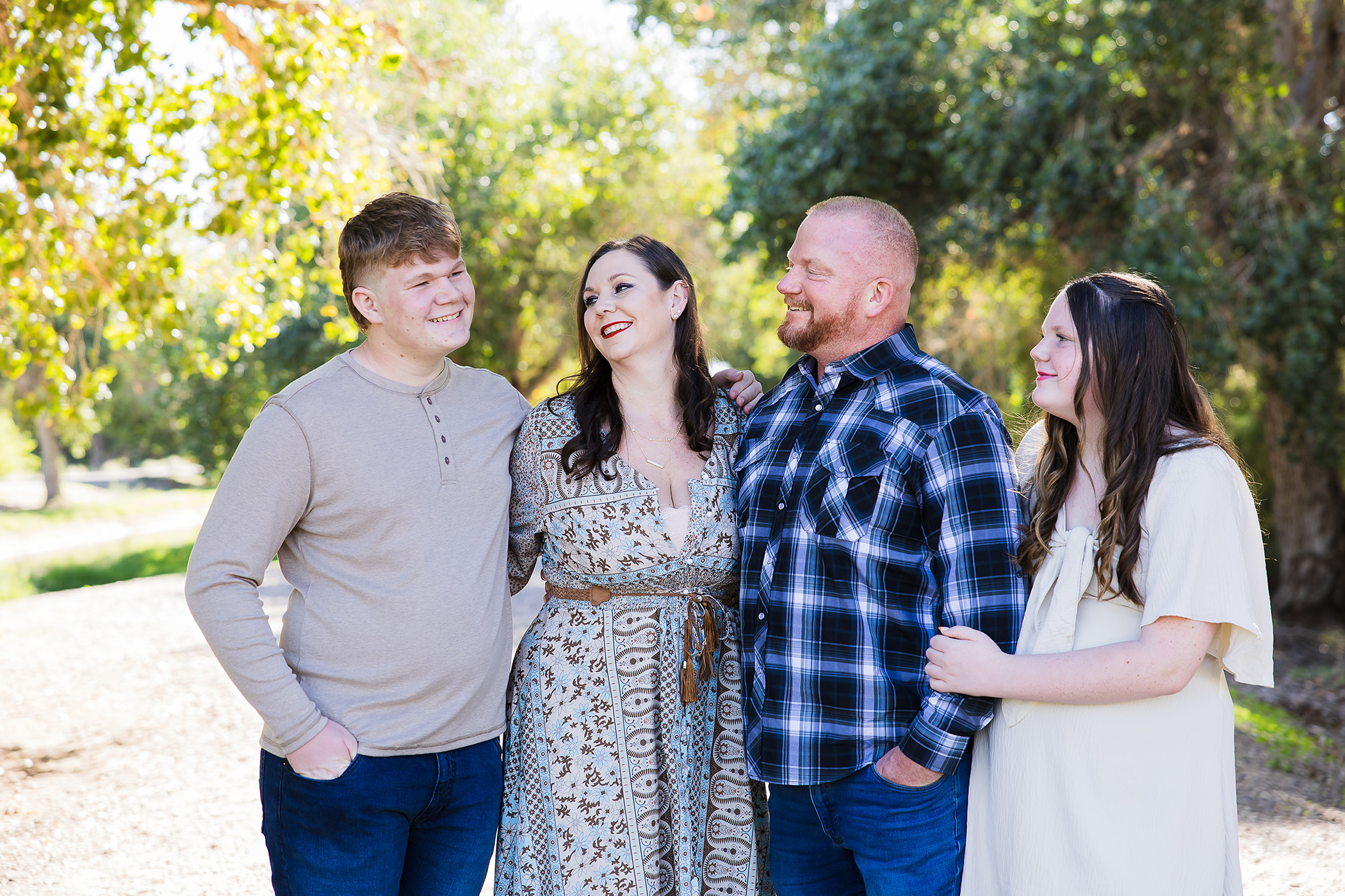 Family laughing together in a tree area.