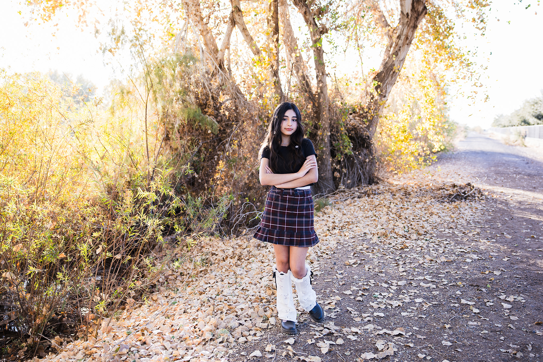 Teenager in a tree area with nice light coming through the trees.