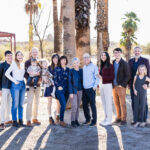 Extended family at Papago Park with palm trees and water in background.