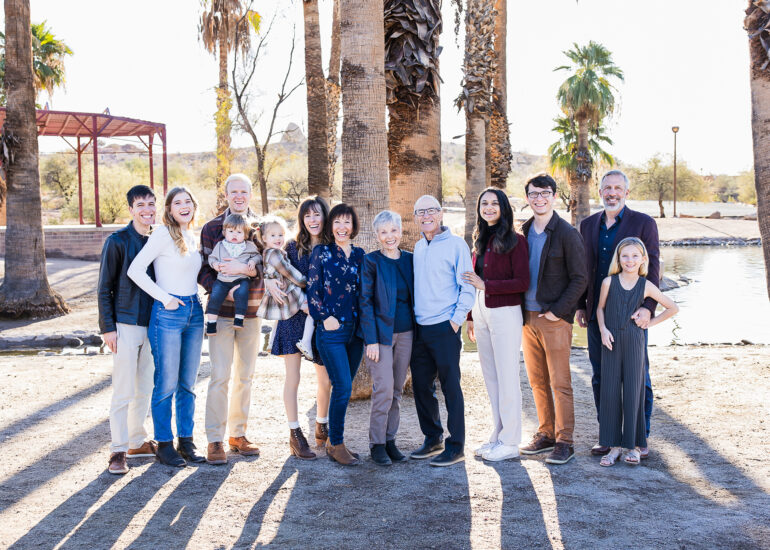 Extended family at Papago Park with palm trees and water in background.