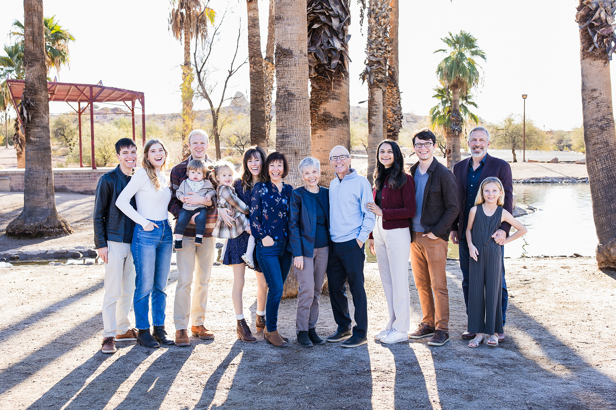 Extended family at Papago Park with palm trees and water in background.