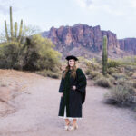 graduate in medical cap and gown in front of superstition mountain
