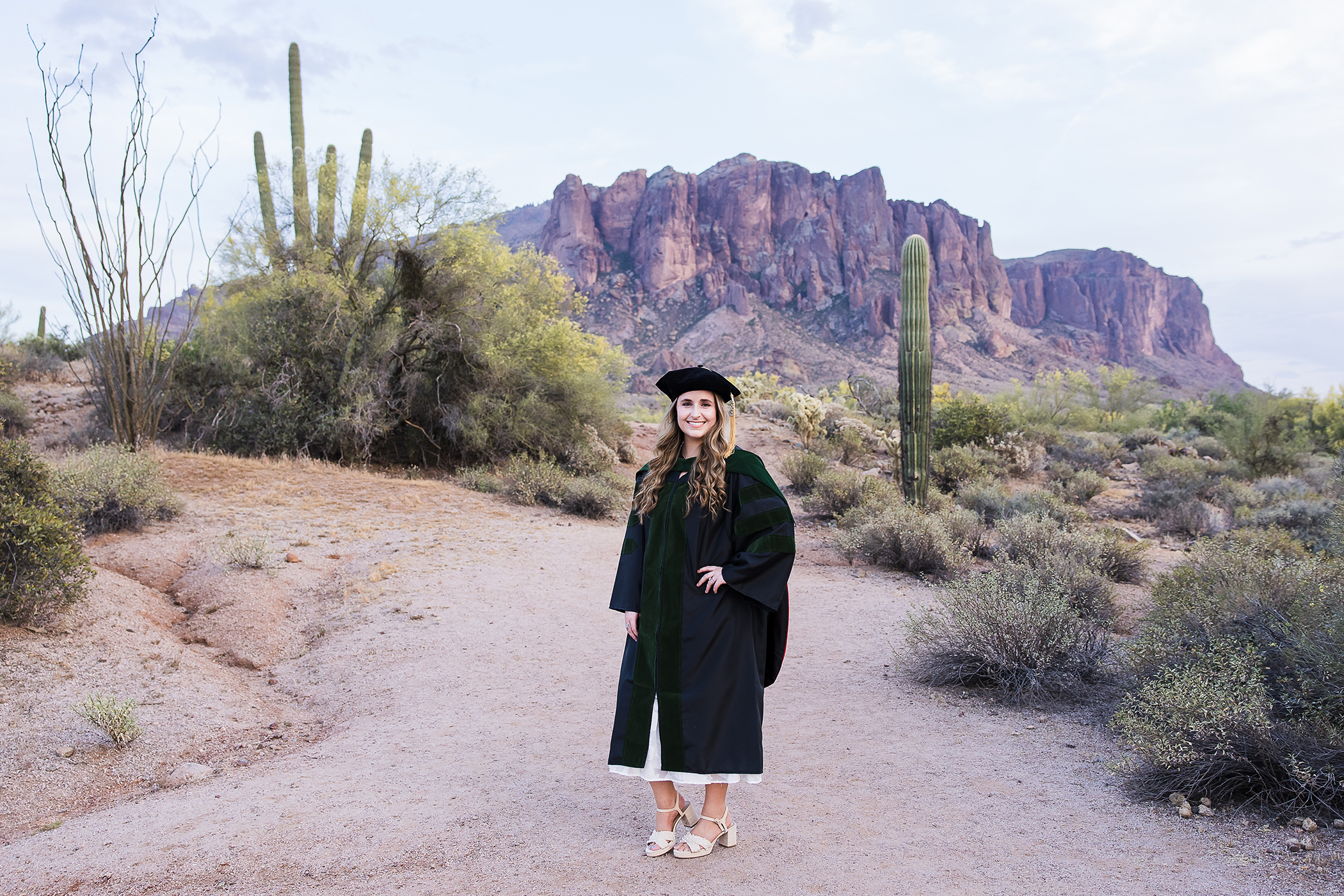 graduate in medical cap and gown in front of superstition mountain